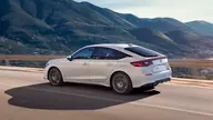 Honda Civic Elegance, tres cuartos trasero en marcha, con montañas al fondo