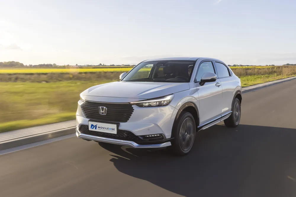 Honda HR-V Elegance, tres cuartos delantero en marcha por una carretera entre campos