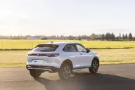 Honda HR-V Elegance, tres cuartos trasero en una pista asfaltada junto a un prado