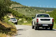 KGM Musso D22 Pro, vista trasera en una carretera entre olivares