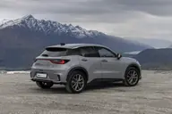 Lexus LBX Elegant Black, tres cuartos trasero con montañas nevadas
