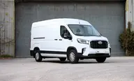 MAXUS Deliver 9 L3H2 Pro, tres cuartos delantero bajo, enseña todo el costado, ante un portón industrial