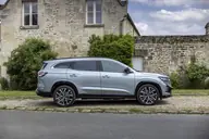Renault Espace Techno E-Tech, lateral ante una casa de piedra con jardín