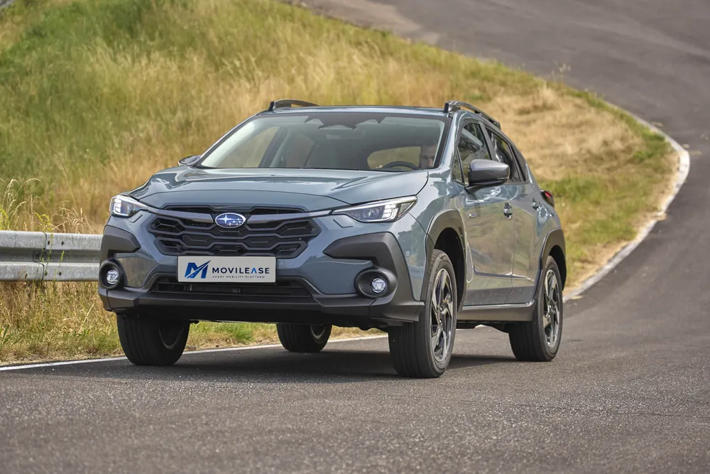Subaru Crosstrek Hybrid Field, tres cuartos delantero en carretera de montaña con prado