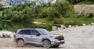 Subaru Forester Hybrid Field, tres cuartos delantero vadeando la orilla de un lago de montaña