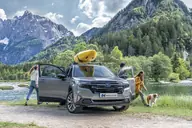 Subaru Forester Hybrid Field, frontal junto a un lago, con las puertas abiertas y una familia